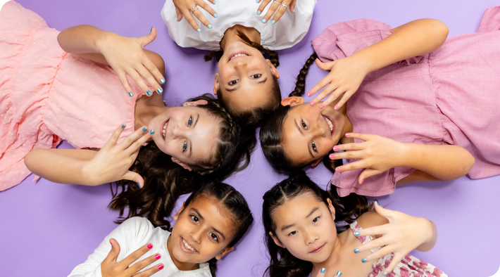 Girls laying down and showing their painted nails.