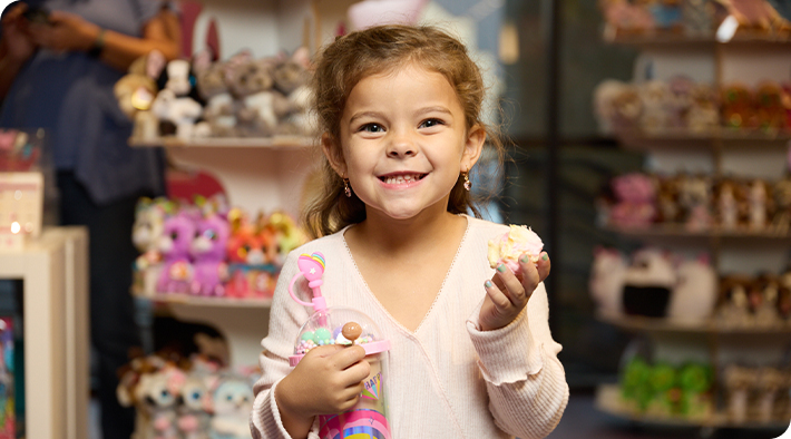 A girl smiling at the camera in a Sweet & Sassy gift shop.